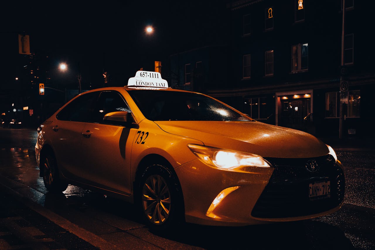 about-01 A yellow taxi waiting at night in London, Ontario, Canada. Urban transportation captured with street lights.
