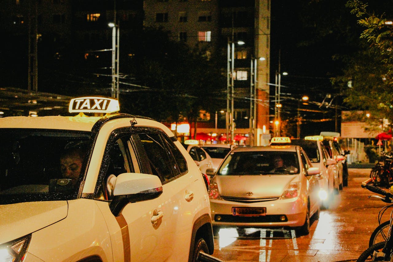 services-03 Taxis lined up under streetlights in Salzburg, Austria, captured at night.