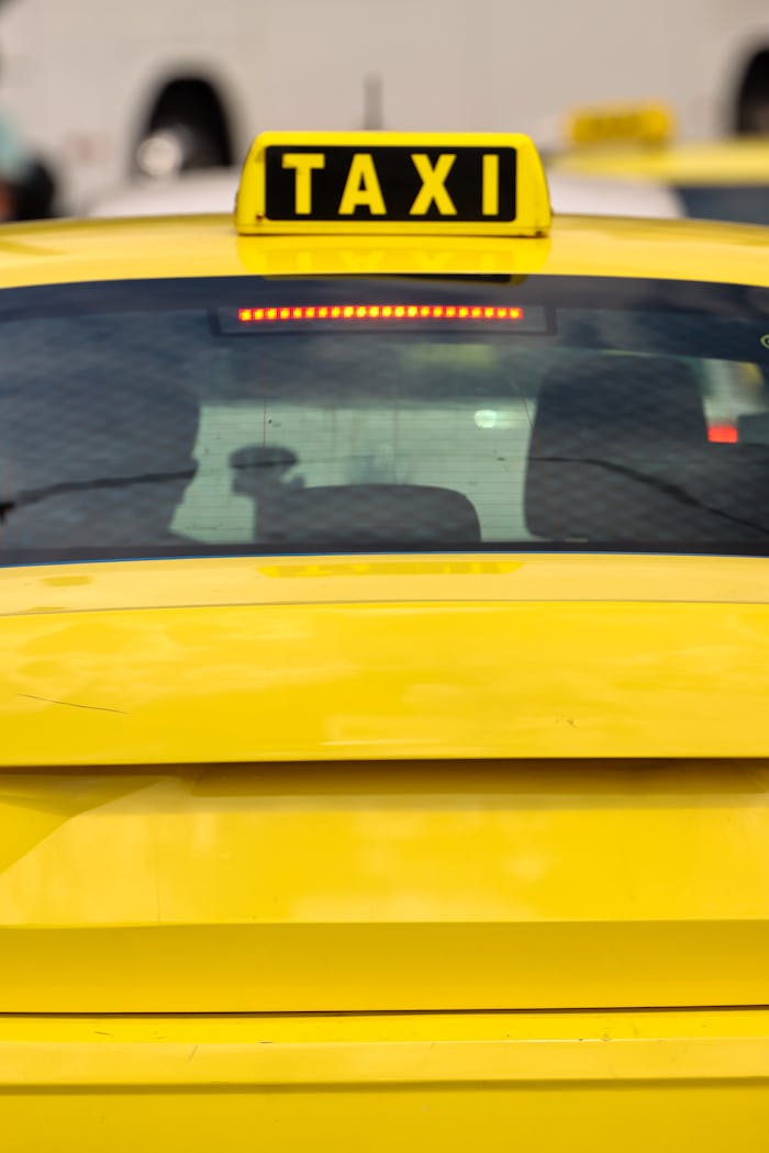 contact-img Close-up of a yellow taxi in Athens, Greece, highlighting the bright sign and urban setting.
